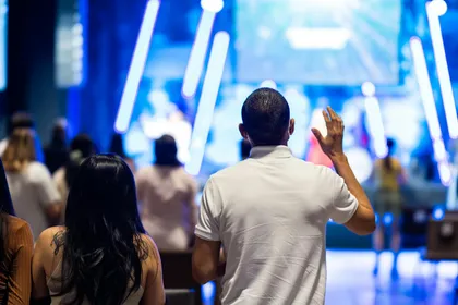 man raising his hands during worship