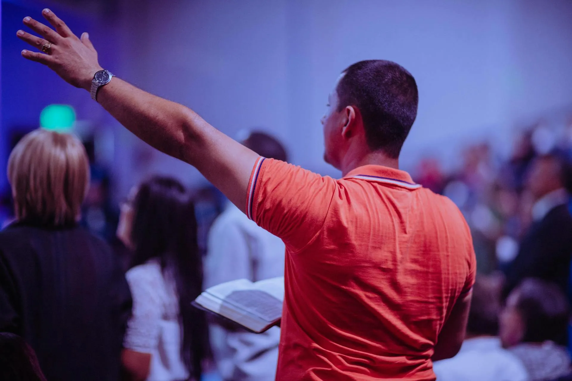 man raising his hands during worship