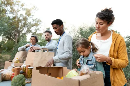 adults and a child passing out food supplies